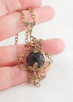 This very dramatic 40's necklace has lots of dimension and texture with a center faceted dome onyx stone set in swirled brass and leaves hangs on a 16 1/2 inch rolo links brass chain with a spring roll clasp which works well the pendant measures 2 by 1 1/4 and is 1/2 of an inch in depth I believe this is a Czech necklace, but I do not see any marks in excellent condition and way better than my picspromise! If you love sterling silver and other vintage necklaces, be sure to check out others I hav Vintage Necklace With Large Pendant For Evening, Vintage Large Pendant Necklace For Evening, Vintage Evening Necklace With Large Pendant, Vintage Onyx Gold Jewelry, Vintage Gold Onyx Jewelry, Vintage Locket Necklace For Evening, Black Vintage Necklace With Charm, Vintage Black Jewelry With Antique Finish, Vintage Black Brass Necklace