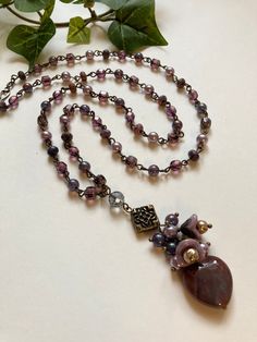 Stunning beaded pendant necklace features Czech glass florals with misty lilac pearls draping over a muted red jasper heart. The linked chain part of this beauty patterns the same lilac pearls with more Czech glass beads in shades of grape and plum and small faceted purple lace agate rondelles. Vintage finish brass wire and finding are used throughout including the graceful simple hook and loop clasp. Truly a treasure of color and bohemian style. * Measures 30” long with a 3” pendant drop * R Bohemian Purple Beaded Necklaces With Czech Glass, Bohemian Purple Necklace With Heart Beads, Misty Lilac, Glass Heart Necklace, Czech Glass Necklace, Beauty Patterns, Muted Red, Beaded Pendant Necklace, Handcrafted Artisan Jewelry