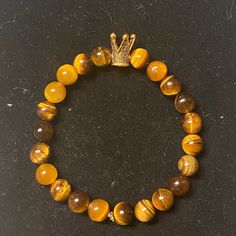 Tiger’s Eye Chakra Bracelet With Crown Charm Casual Brown Bracelet Jewelry, Casual Brown Round Beaded Jewelry, Casual Brown Beaded Bangle Bracelets, Elegant Adjustable Brown Stretch Bracelet, Elegant Hand-strung Brown Bracelet, Everyday Brown Beaded Bracelets, Casual Brown Bangle Jewelry, Casual Brown Beaded Bracelets For Gift, Casual Brown Bracelets For Everyday Wear