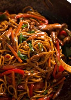 stir fry noodles with chicken and vegetables in a wok