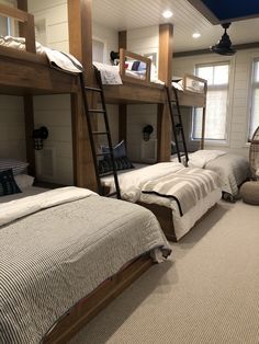 there are bunk beds in the room with ladders on each bed and pillows on the floor