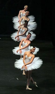 four ballerinas in white tutus are lined up