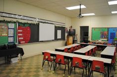 an empty classroom with desks and chalkboards on the wall, in front of a checkered floor