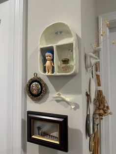 there is a shelf with some pictures and other items on the wall next to it