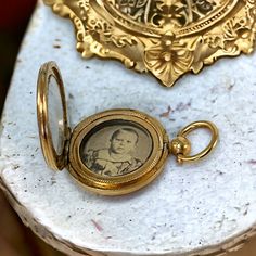 Step back in time with this exquisite late Victorian or early Edwardian gold-filled mourning locket pendant. 🕰️🌹 This treasured piece encases a sepia picture of a little boy behind a glass window, preserving a poignant memory from the past. Open it to reveal the picture protected by another round glass frame. 📸✨  The picture is not straight but is placed sideways in the locket so the person wearing it on a chain can easily take it in her hand and look at the little boy.  Though unsigned, this Victorian Jewelry With Coin Pendant, Victorian Locket Pendant Necklace For Keepsakes, Victorian Yellow Gold Locket Necklace For Keepsake, Victorian Yellow Gold Locket Necklace Keepsake, Victorian Yellow Gold Medallion Locket Necklace, Antique Locket Necklace For Keepsake, Vintage Yellow Gold Locket Necklace For Memorial, Vintage Yellow Gold Memorial Locket Necklace, Antique Medallion Jewelry For Commemoration