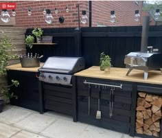 an outdoor kitchen with bbq, grill and firewood stacked on the counter top