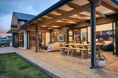 an outdoor living area with wooden decking and glass doors leading to the dining room