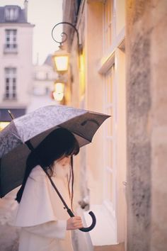 a woman walking down the street with an umbrella