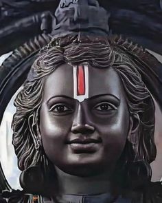 a close up of a statue of a woman with red and white stripes on her forehead