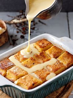 a pan filled with bread and sauce being drizzled on top of it