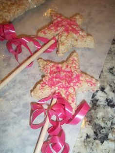 three star shaped cookies tied with pink ribbon on top of a counter next to candy canes