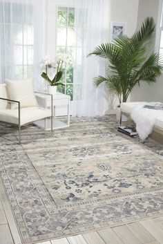 a living room with a large rug on the floor and a chair in front of it