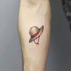 a small tattoo on the leg of a man with a hat on it's head