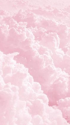 the sky is filled with fluffy clouds in pink and white colors, as seen from an airplane