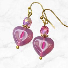 Pink heart earrings, crafted with Czech glass beads. These dangle earrings are the perfect accessory to add a touch of romance to any outfit. The beautiful pink hues of the glass beads catch the light with every movement, creating a dazzling display that will surely captivate all eyes.  Artisan glass hearts produced in small quantities in Czech Republic  Hypoallergenic ear wires (nickel and lead free). Choose ear wire style at checkout. A gift for you or someone special, earrings are carded and Pink Heart Beads Drop Earrings, Pink Dangle Beaded Earrings For Valentine's Day, Pink Heart Beads Dangle Jewelry, Pink Nickel-free Double Heart Earrings, Pink Heart Beaded Earrings For Gifts, Pink Heart Beads Beaded Earrings For Gift, Pink Beaded Earrings With Heart Beads As Gift, Pink Heart Earrings With Ear Wire For Valentine's Day, Pink Heart-shaped Nickel-free Earrings