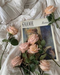 some pink roses laying on top of a bed