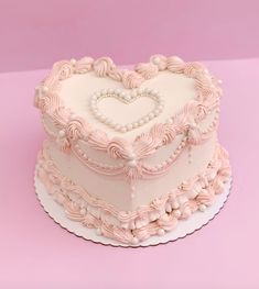 a heart shaped cake on a pink background