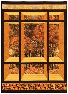 a quilted wall hanging with autumn trees in the background