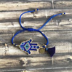 two bracelets with beads and tassels on wooden background