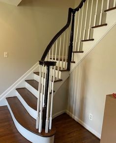 an empty room with stairs and hard wood flooring