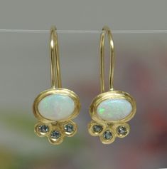 "Opal gold earrings, 18k gold bezel, 14k gold wire, oval Opal and light green small Sapphires. Unique dainty stunning dangle earrings. Flower shape: beautiful oval Opal sets in 18k gold bezel, with 3 light green Sapphires set in three tiny leaves. I find the combination between the 18k gold the green Sapphires and the Opal extraordinary. These earrings can be the perfect earrings for a bride with her white dress and her big smile on her special day. You can wear these earrings every day, with a Oval Yellow Gold Earrings With Rose Cut Diamonds, Green Sapphire Earrings, Bridal Dangle Earrings, Sapphire Earring, Opal Earring, Hanging Earring, Handmade Gold Ring, Unique Opal, Diamond Fashion Jewelry