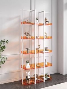 a white and orange shelving unit in an empty room with potted plants on the shelves