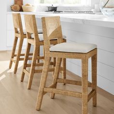 three wooden stools sitting in front of a counter