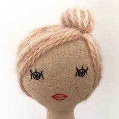 a doll with blonde hair and black eyes