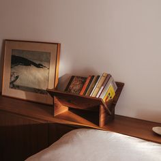 a book shelf with books on it next to a bed