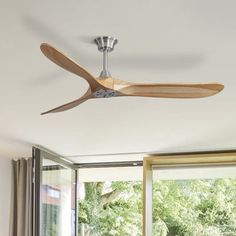 a ceiling fan that is hanging from the ceiling in a room with windows and sliding glass doors