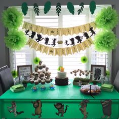 a green table topped with cake and cupcakes