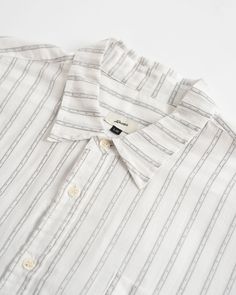 Much like our Leisure Pants, we’ve coined this our bleasure shirt: half-business, half-pleasure. Utilizing a lightweight, 100% cotton fabric from Japan, this fine stripe is sure to be a staple in your warm weather wardrobe this High Summer 100% Organic Cotton Dobby fabric 100 GSM Split hem Classic collar Front chest pocket Slightly oversized fit - size down if you want a more fitted look Fabric sourced from Japan Made in Canada Classic Summer Shirt With Horizontal Stripes, Striped Relaxed Fit Shirt For Business Casual, White Shirt With Horizontal Stripes In Relaxed Fit, Striped Everyday Summer Shirt, Summer Pinstripe Cotton Shirt, White All Over Print Beach Camp Shirt, White Tropical Cotton Camp Shirt, White Horizontal Stripe Relaxed Fit Shirt, White Unstructured Cotton Camp Shirt