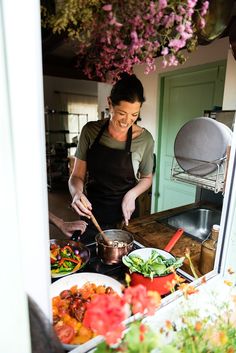 a woman in an apron preparing food on a stove