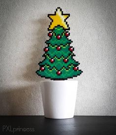 a small christmas tree sitting on top of a white cup