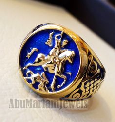 St George's and the dragon heavy man ring round 10K gold historical religious Greek Orthodox Christian all sizes jewelry Risk free Quality guarantee policy : If you are not satisfied with your item for any reason simply send it to us and you will get a replacement or refund . gold : 10 k gold Approx. ring weight : 18.00 grams stamped 10K nice gift box included . certificate invoice from our shop of weight and gold purity . 10K Gold is used and blue enamel. Face width 18 mm , band width 7 mm FULL Collectible Gold Rings With Historical Design, Ceremonial Blue Engraved Jewelry, Blue 14k Stamped Signet Ring, Blue Engraved Jewelry For Ceremonial Occasion, Blue Hallmarked Signet Ring, Heirloom Blue Signet Ring, Antique Collectible Enamel Ring, Traditional Hallmarked White Gold Signet Ring, Engraved 14k Gold Enamel Ring