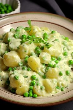 a plate filled with pasta and peas on top of a table