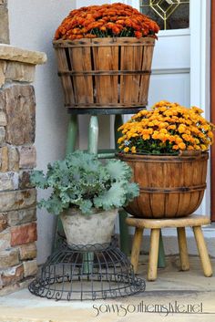 three wooden baskets filled with flowers sitting on top of a step next to a door