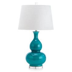 a blue table lamp with a white shade on the base and a light in front of it