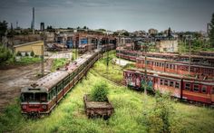 an old train yard with abandoned trains in the foreground