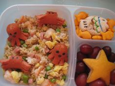 a plastic container filled with rice, grapes and other food items next to a star shaped cookie