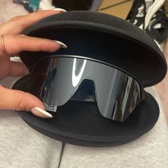 a woman's hand is holding on to some sunglasses that are in a case