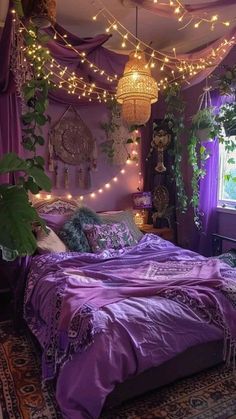 a bed with purple sheets and lights hanging from the ceiling above it, in front of a window