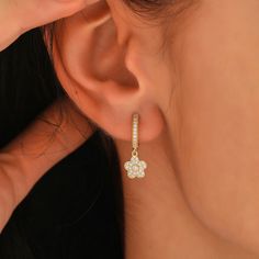 This solid 10k, 14k, or 18k gold huggie earring features a beautiful flower design that dangles elegantly. The high-quality Swarovski cubic zirconia gemstones add a stunning shine and sparkle to the already gorgeous earring. The flower shape is intricately crafted with attention to detail, making it a unique and stunning addition to any jewelry collection. The huggie style of the earring ensures a comfortable and secure fit, while the dangling starfish adds a touch of playful elegance. Perfect for any occasion, this earring is sure to make a statement and be a treasured piece for years to come. * 100% 10K 14k 18K Solid Yellow Gold (Not Gold Vermail or Not Gold Plated) * Sold as Pair * Swarovski Cubic Zirconia clear simulated diamonds * 0.50inch outer, 0.38inch inner diameter * 13mm outer, Huggie Earrings With Flower Charm For Gift, Huggie Earring, Beautiful Flower Designs, Flower Earring, A Beautiful Flower, Gemstones Jewelry, Gorgeous Earrings, Huggies Earrings, Beautiful Flower