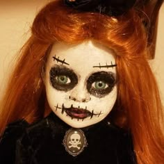 a doll with red hair and black makeup