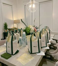 several bags sitting on top of a table in front of a lamp and some flowers