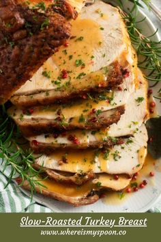 sliced pork roast with gravy on a white plate and green sprigs