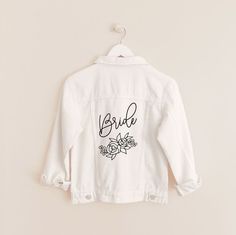 White Bridal denim jacket make the perfect gift for the bride and bridesmaids! Each denim jacket comes with a white floral silhouette design and your choice of “Mrs”“Bride” or Babe” Material :Distressed Lightweight Cotton Denim 72% Cotton 25.5% Polyester 25.5% Rayon Jackets are a classic fit with distressed detailing; small rips. Size Chart NO RETURNS OR EXCHANGES ON PERSONALIZED, SHIRTS, & CLOTHING ITEMS. Care Instructions: Cold wash on gentle cycle. Hang Dry. Do NOT Bleach. Iron Medium Tempera Bridal Denim Jacket, Gift For The Bride, Floral Silhouette, White Jean Jacket, Custom Denim, Floral Denim, Floral White, White Bridal, Gift Boutique