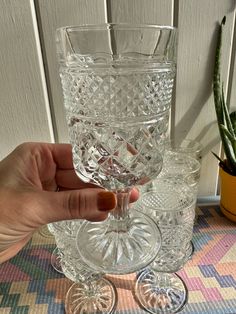 a hand holding a glass on top of a table