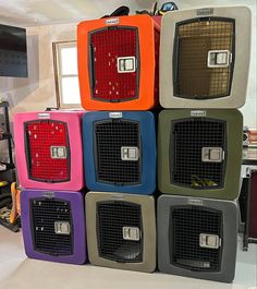 several different colored dog crates stacked on top of each other