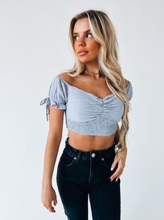 DETAILS: Our Morrilyn Crop Top is an off the shoulder crop top is loaded full of details. This top features a padded bust, smocked bodice, and off the shoulder neckline. The sleeves on this top feature elastic to give the top a more secure fit. This top has a lot of stretch throughtout if in between sizes we recommend sizing up. CONTENT & CARE: SELF: 100% Polyester SIZE & FIT: Model is 5'6" The model is wearing a size medium Fits true to size The Fabric has stretch Trendy Ruched Cropped Smocked Top, Trendy Smocked Crop Top, Cropped Tube Top With Smocked Bodice, Spring Flirty Tube Top With Smocked Bodice, Flirty Smocked Tube Top For Spring, Flirty Smocked Bodice Tube Top For Spring, Spring Smocked Bodice Bandeau Crop Top, Trendy Crop Top With Smocked Bodice And Puff Sleeves, Fitted Off-shoulder Smocked Top For Day Out